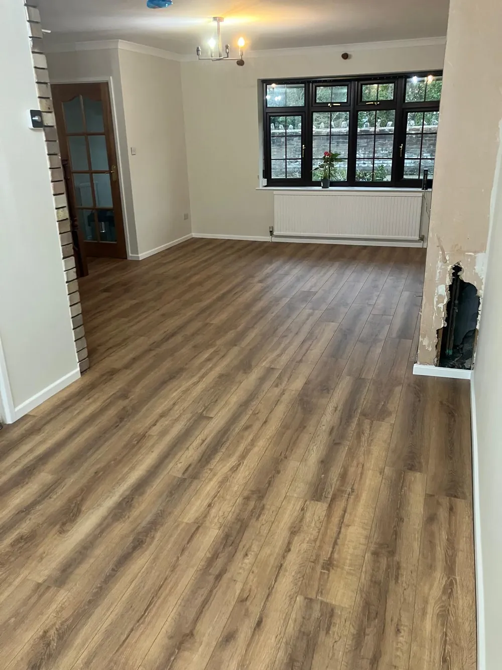 Laminate flooring fitted in a living room with a bay window