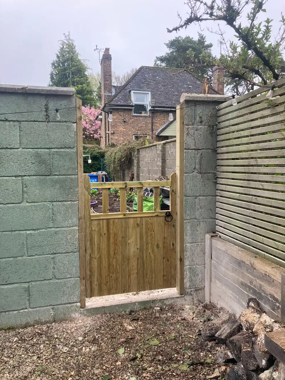 Bespoke timber garden gate hung between stone pillars