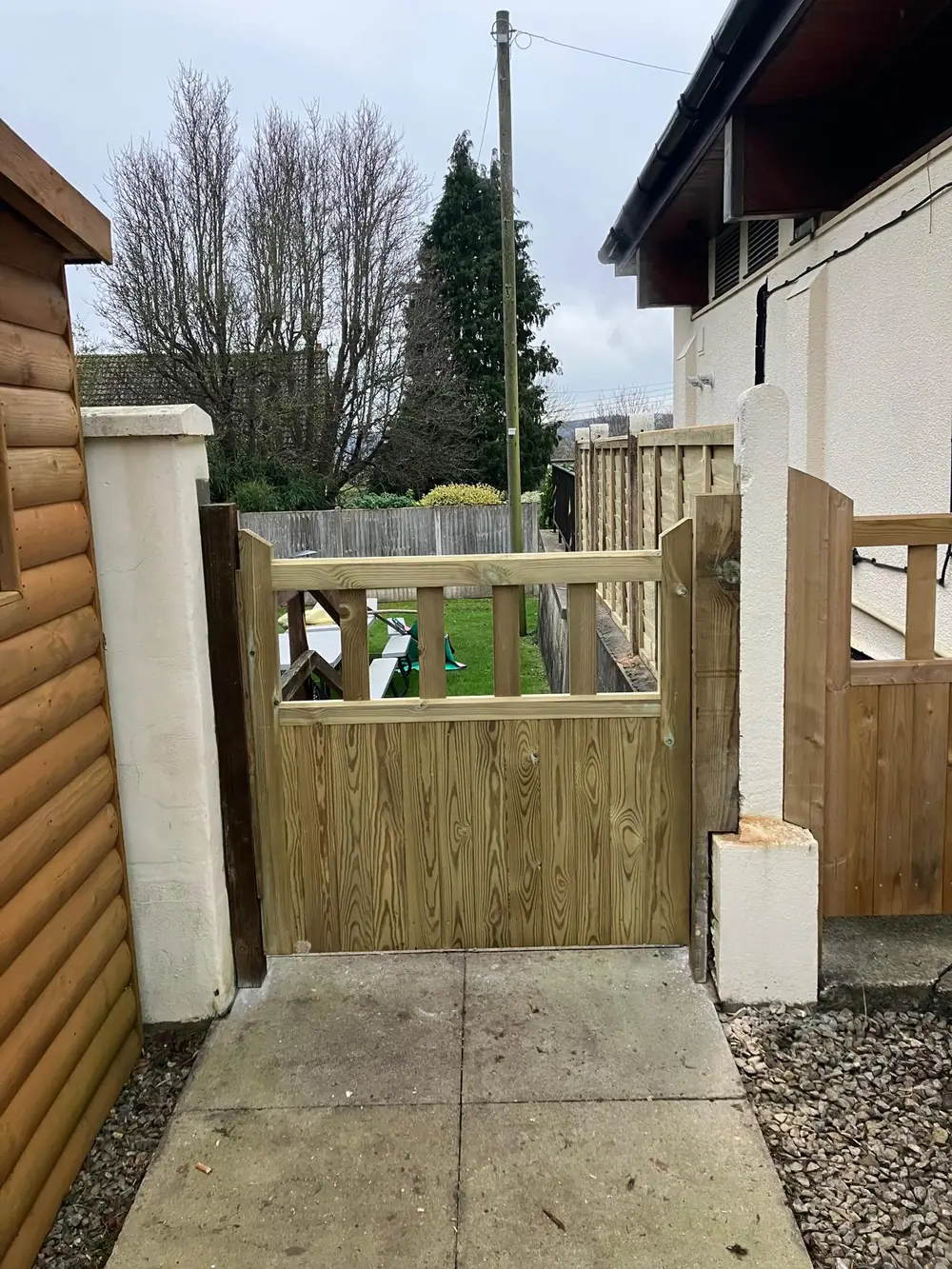 Timber side access gate fitted between a house and a shed